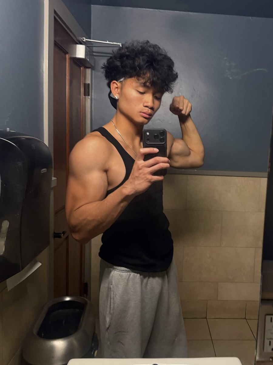 Ethan after, flexing in a black tank top