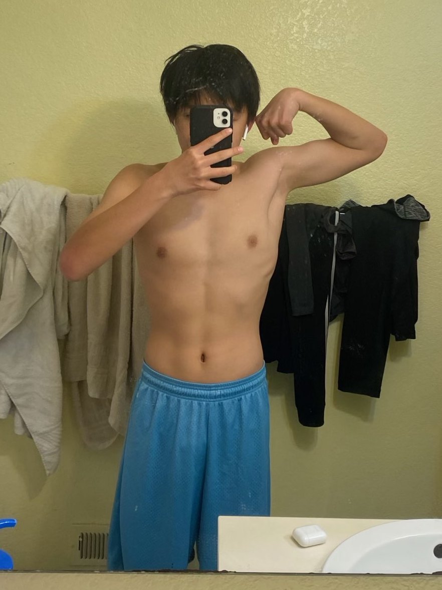 Joshua Tran before, flexing in a mirror with a slim frame